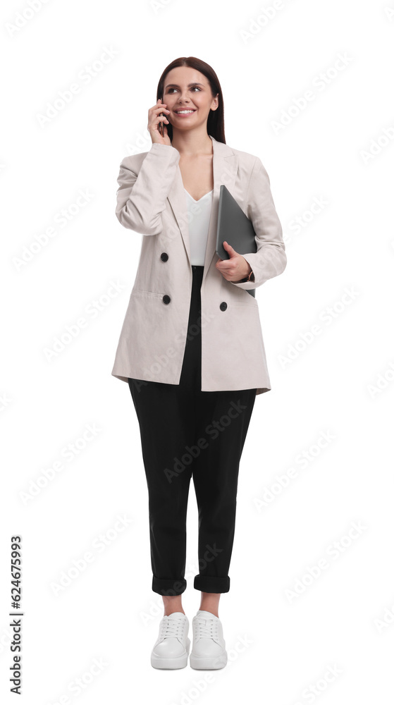 Beautiful businesswoman in suit with laptop talking on smartphone against white background Beautiful businesswoman in suit with laptop talking on smartphone against white background