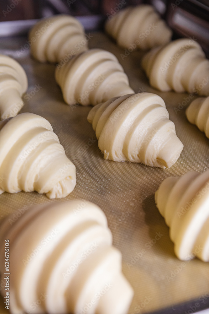 Sheet of proofed croissant dough baking