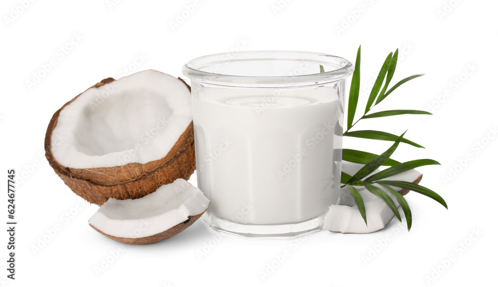 Glass of delicious vegan milk, coconut pieces and green leaves on white background Glass of delicious vegan milk, coconut pieces and green leaves on white background