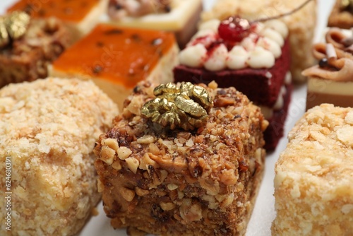 Pieces of different delicious cakes on table  closeup