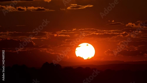 Beautiful time lapse of the sun setting behind the clouds.