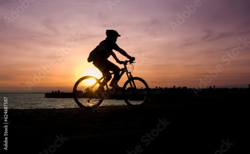 Silhouette of cyclist biking at the sunset