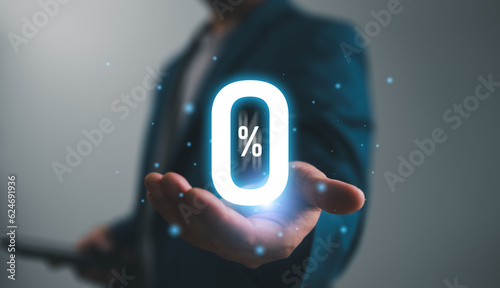 Businessman holding glowing zero percentage or 0 percent for special offer of shopping department store and discount concept. Interest rate, installment payment, promotion, marketing, boost sales