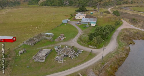 Aerial: Farmland and homestead Paturau, South Island, New Zealand photo