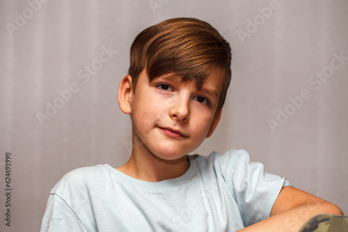 nine year old boy looks at the camera and smiles. close-up portrait