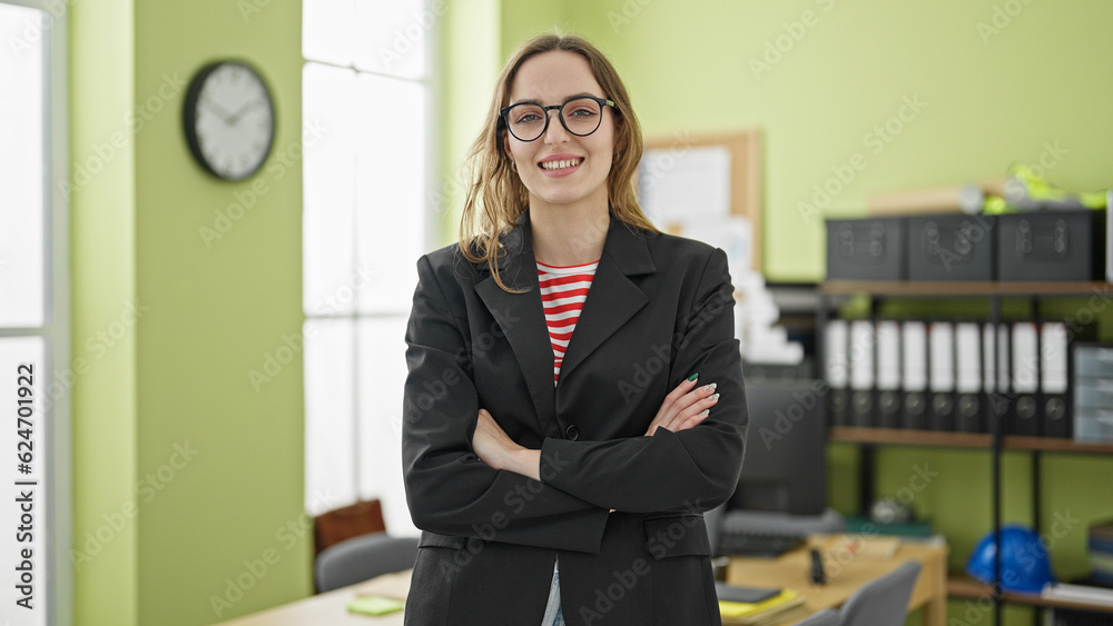 Young blonde woman business worker standing with arms crossed gesture smiling at office Young blonde woman business worker standing with arms crossed gesture smiling at office