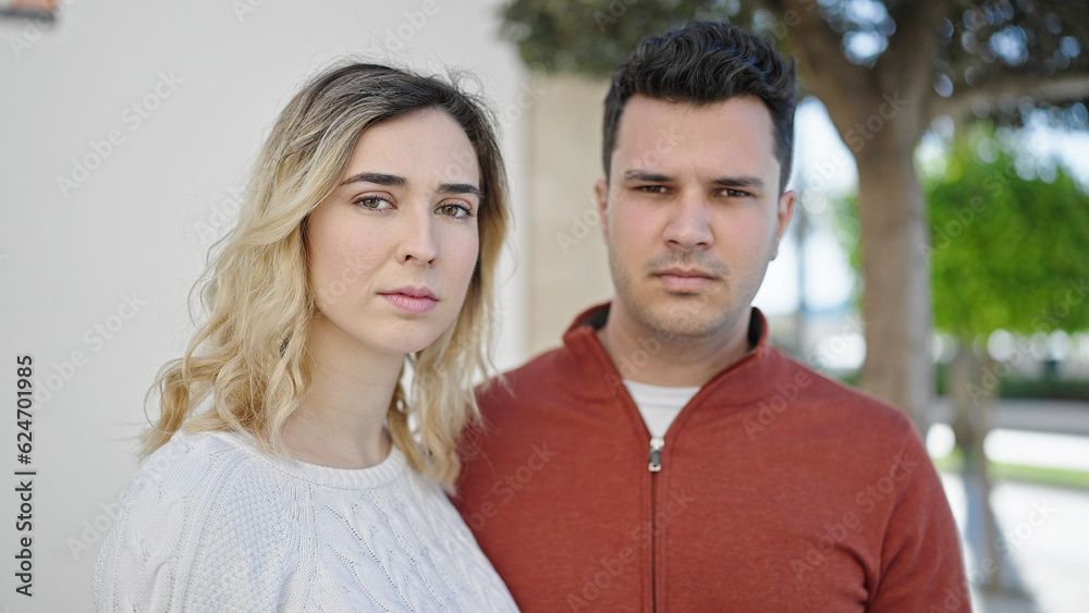 Man and woman couple standing together with relaxed expression at street Man and woman couple standing together with relaxed expression at street