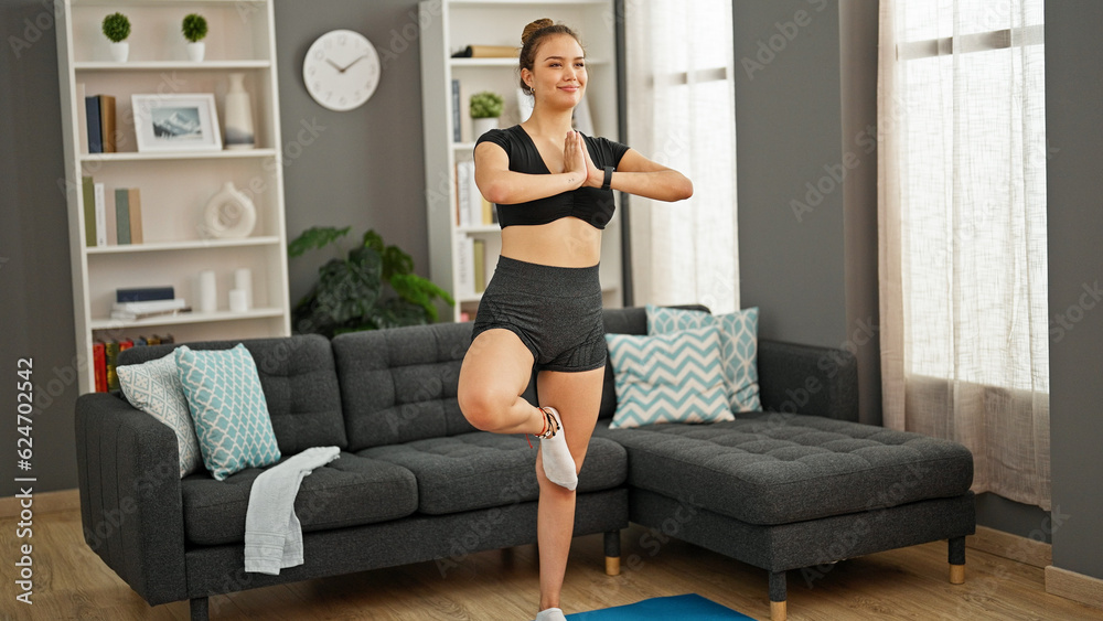 Young beautiful hispanic woman smiling confident training yoga at home