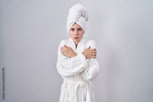 Obraz na płótnie Blonde caucasian woman wearing bathrobe shaking and freezing for winter cold wit