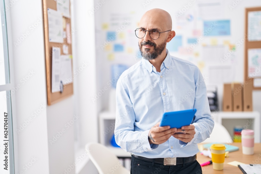 Young bald man business worker smiling confident using touchpad at office Young bald man business worker smiling confident using touchpad at office