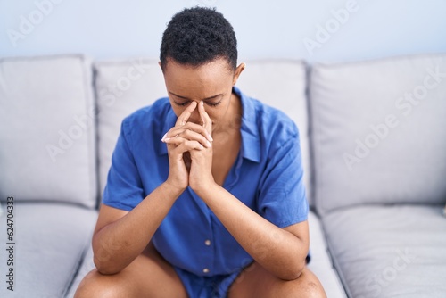 African american woman stressed sitting on sofa at home