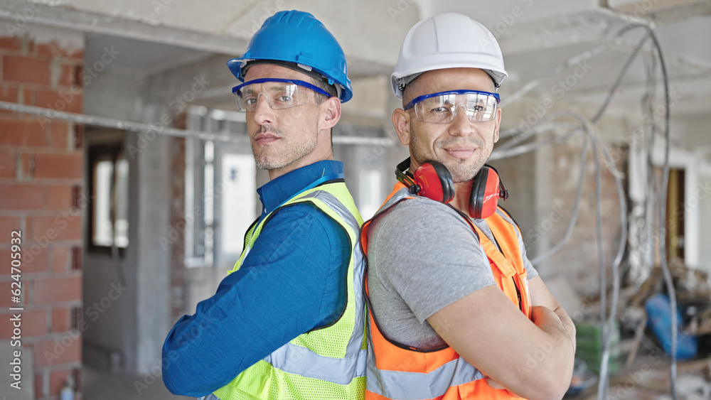 Two men builders smiling confident standing with arms crossed gesture at construction site Two men builders smiling confident standing with arms crossed gesture at construction site