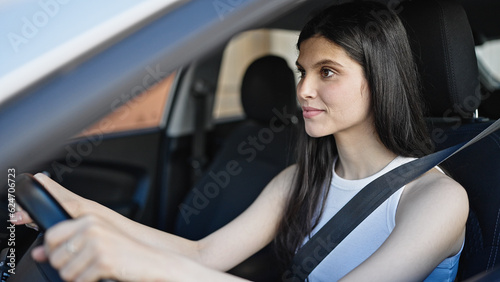 Young beautiful hispanic woman smiling confident driving car at street © Krakenimages.com