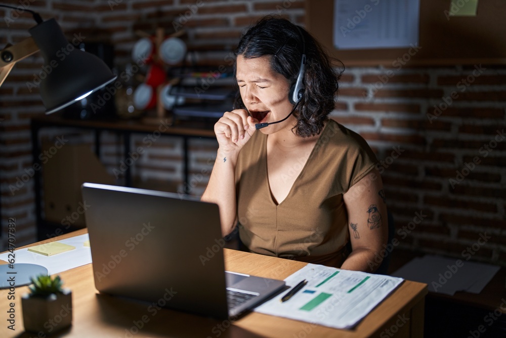 Young hispanic woman working at the office at night feeling unwell and coughing as symptom for cold or bronchitis. health care concept. Young hispanic woman working at the office at night feeling unwell and coughing as symptom for cold or bronchitis. health care concept.