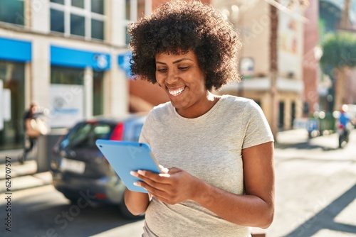 African american woman smiling confident using touchpad at street