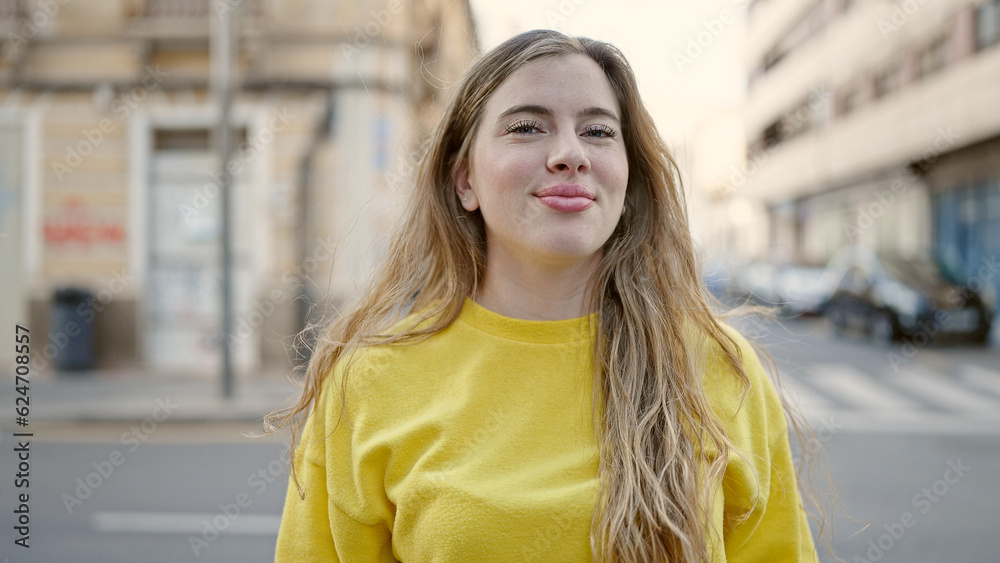 Fototapeta premium Young blonde woman smiling confident standing at street