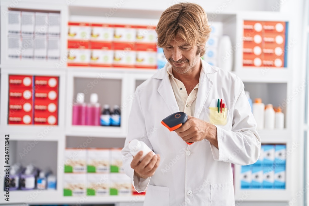 Young man pharmacist scanning pills bottle at pharmacy