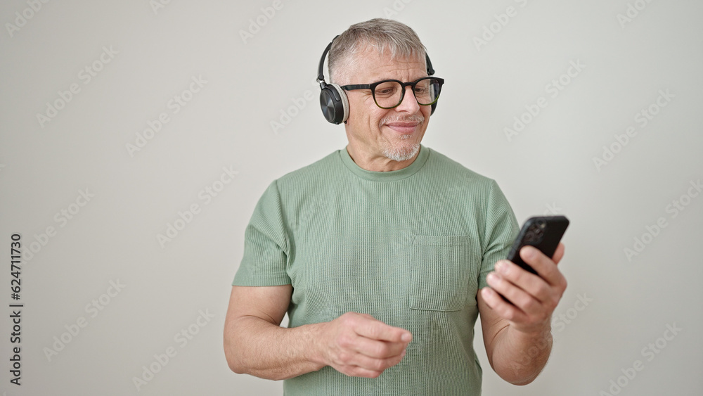 Middle age grey-haired man using smartphone wearing headphones over isolated white background