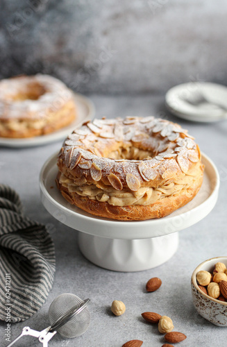 Canvas Print Round-shaped classic French dessert Paris Brest with almonds and hazelnuts on a