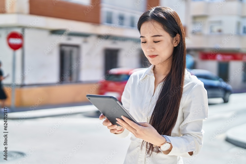 Young chinese woman smiling confident using touchpad at street Young chinese woman smiling confident using touchpad at street