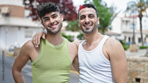 Two men couple smiling confident hugging each other at street