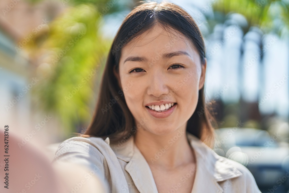 Chinese woman smiling confident making selfie by camera at park Chinese woman smiling confident making selfie by camera at park