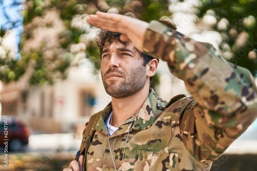 Young man army soldier doing militar salute at park