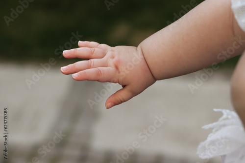 Baby hand with white dress outdoors © OzgeTemur