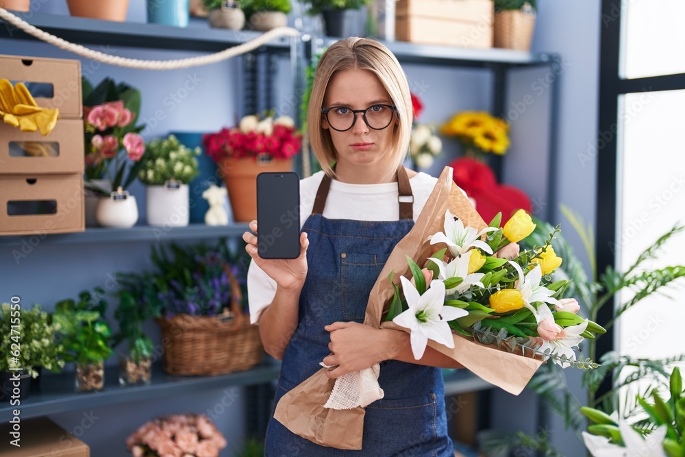 Young caucasian woman working at florist shop showing smartphone screen depressed and worry for distress, crying angry and afraid. sad expression.