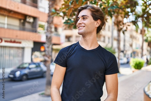 Young caucasian man smiling confident looking to the side at street