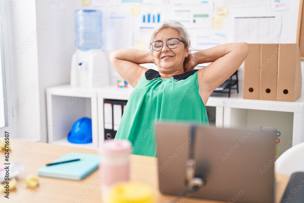 Middle age grey-haired woman business worker relaxed with hands on head at office Middle age grey-haired woman business worker relaxed with hands on head at office