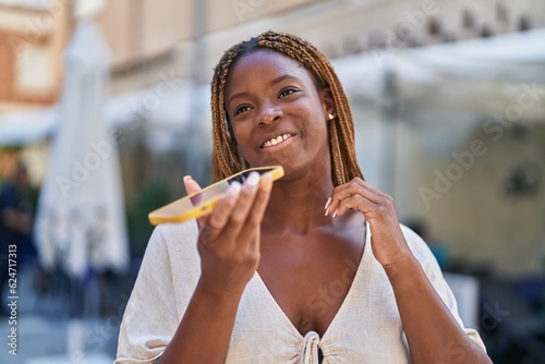 African american woman smiling confident talking on the smartphone at coffee shop terrace