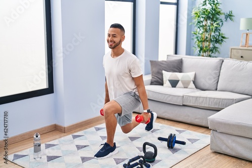 African american man using dumbbells training arms exercise at home