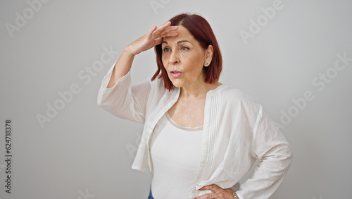 Middle age woman looking for faraway over isolated white background photo