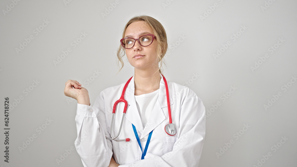 Young blonde woman doctor looking to the side with serious expression over isolated white background Young blonde woman doctor looking to the side with serious expression over isolated white background