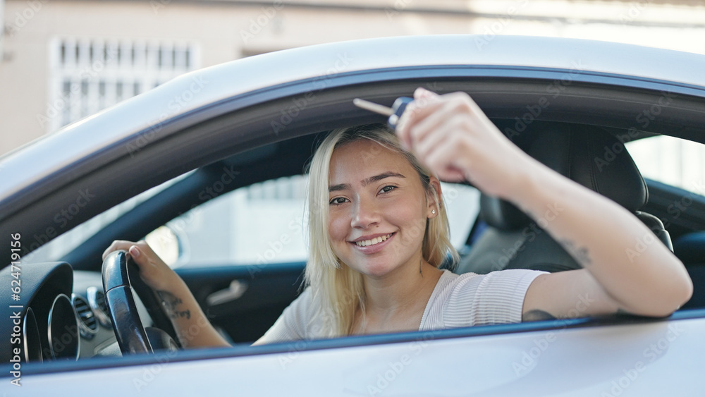 Young beautiful hispanic woman smiling confident holding key of new car at street