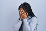 African american woman standing over blue background with sad expression covering face with hands while crying. depression concept.
