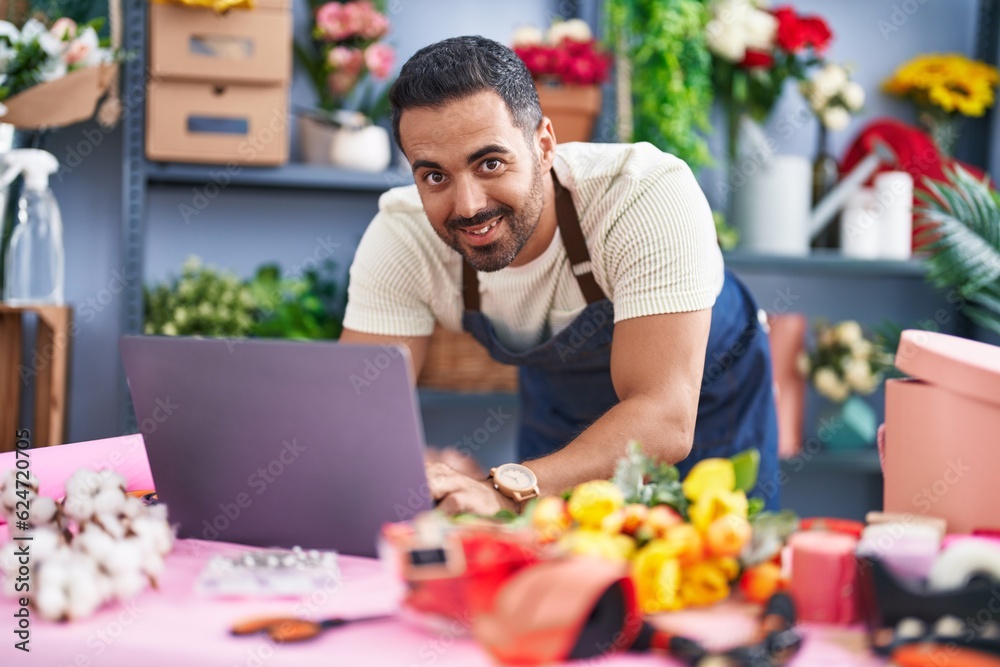 Young hispanic man florist using laptop working at florist Young hispanic man florist using laptop working at florist