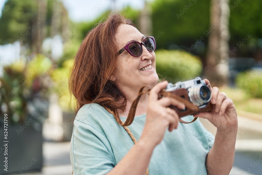 Senior woman tourist smiling confident holding camera at street Senior woman tourist smiling confident holding camera at street