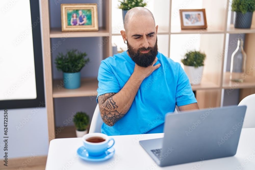 Young bald man using laptop suffering for throat pain at home Young bald man using laptop suffering for throat pain at home