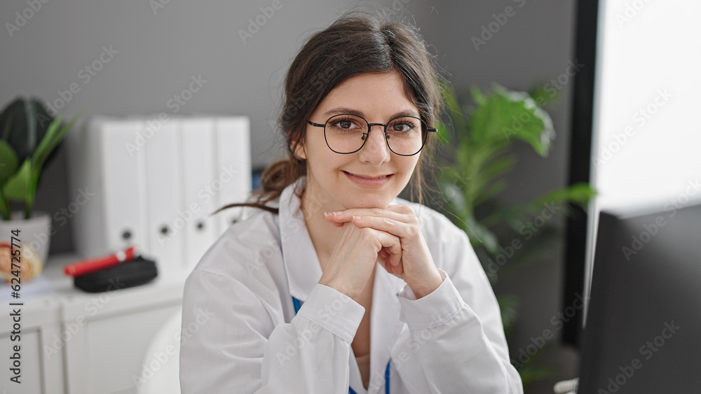 Young beautiful hispanic woman doctor using computer working at clinic Young beautiful hispanic woman doctor using computer working at clinic