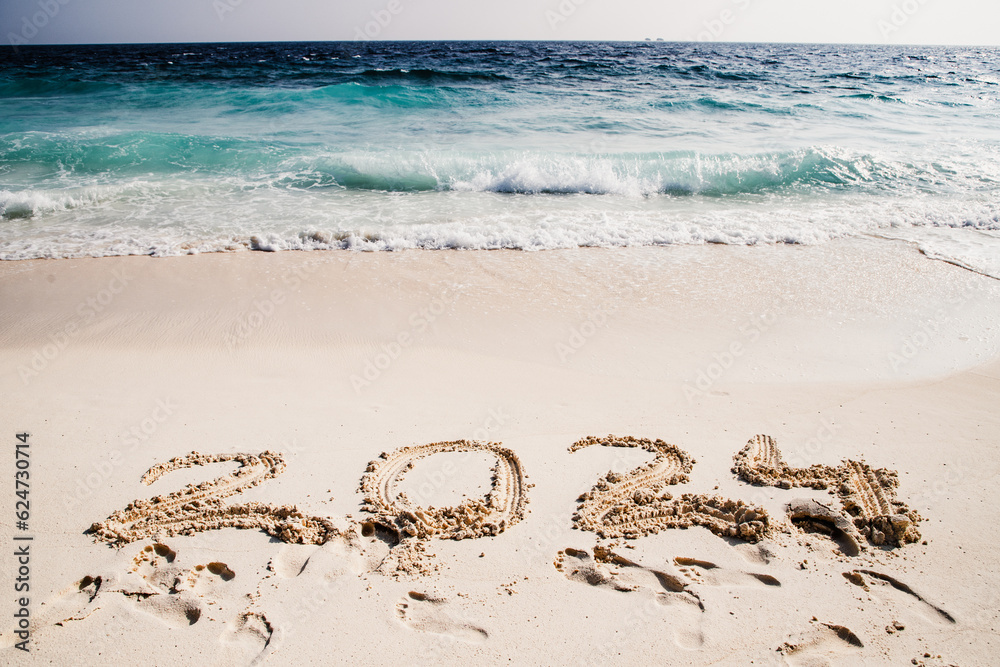 2024 written in white sand on tropical beach, happy New Year 2024 written in white sand on tropical beach, happy New Year