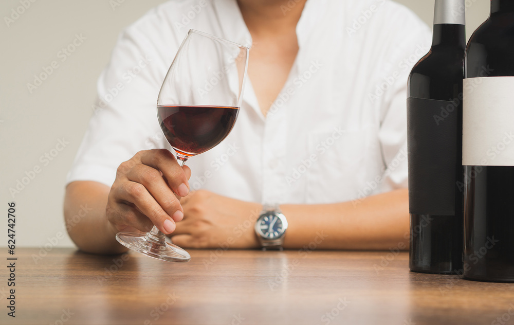 Businessman holding a glass of red wine while sitting at the table. Businessman holding a glass of red wine while sitting at the table.