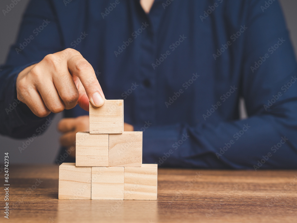 Businessman stacking blank wooden cubes on the table. Businessman stacking blank wooden cubes on the table.
