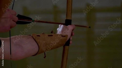 archer tends yew wood bow to shoot an arrow
