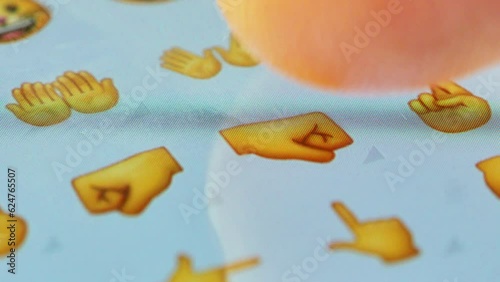 Macro finger scrolling emojis on a virtual keyboard