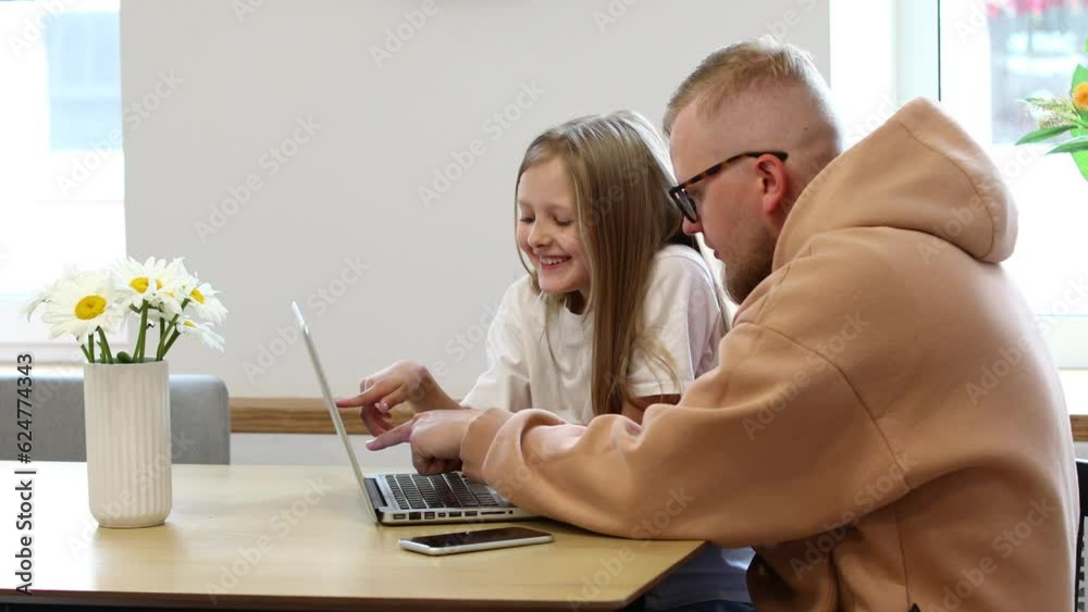 Father and daughter work at the computer. Dad explains something to his daughter. Information Technology. Internet. Classes online. Online learning. 4k video Father and daughter work at the computer. Dad explains something to his daughter. Information Technology. Internet. Classes online. Online learning. 4k video