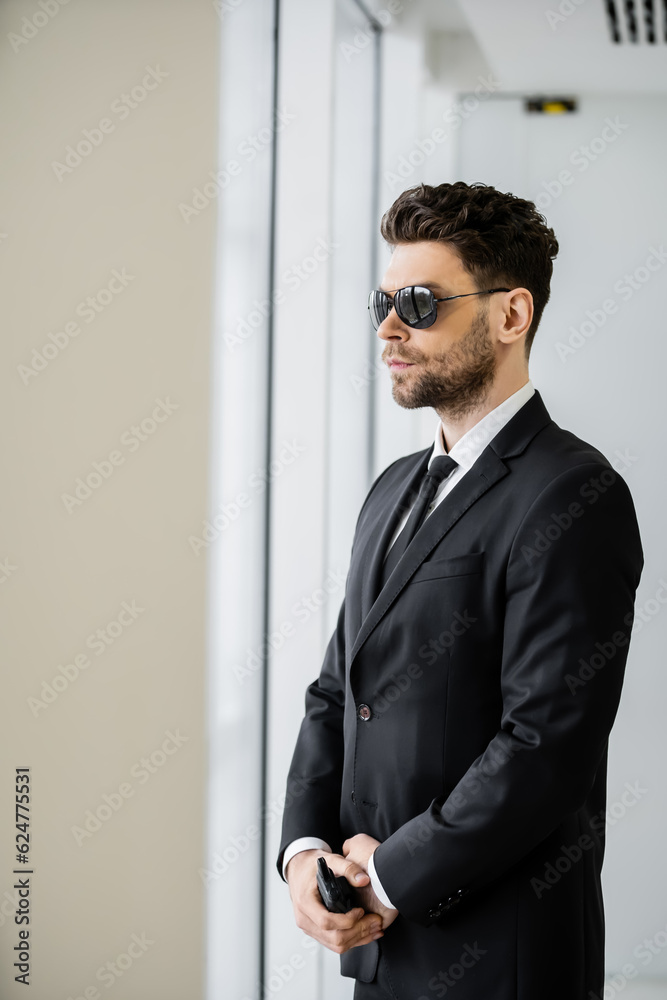 surveillance, bodyguard standing with walkie talkie, handsome security man in sunglasses and black suit with tie, hotel safety management, uniformed guard on duty, professional headshots surveillance, bodyguard standing with walkie talkie, handsome security man in sunglasses and black suit with tie, hotel safety management, uniformed guard on duty, professional headshots