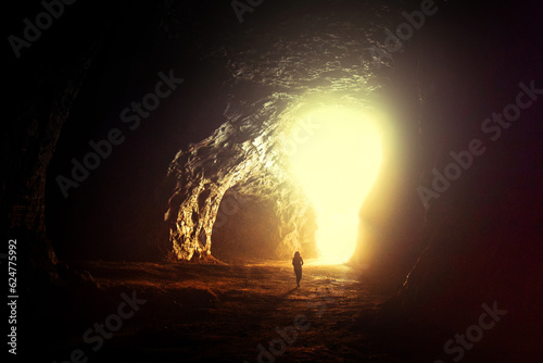 Successful businessman in the dark come out of the cave into light bulb hole, creative idea. Choice, concept. Hope and a new path. Start app. Man leader finds the right way.