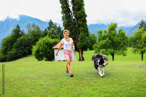 Woman with a dog run on a mountain